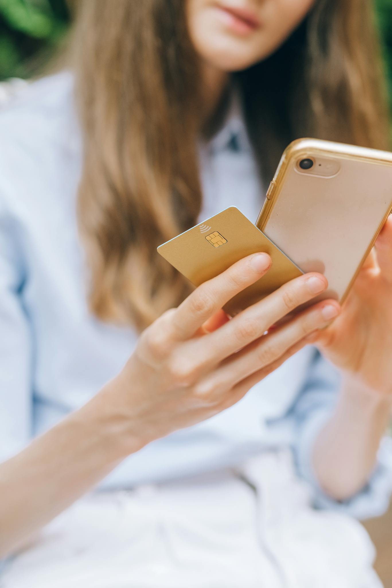 Close-up of a woman shopping online using a smartphone and credit card.